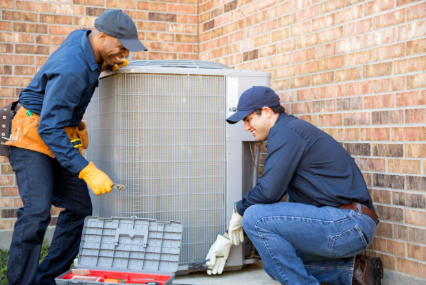 Multi-ethnic team of blue collar air conditioner repairmen at work.