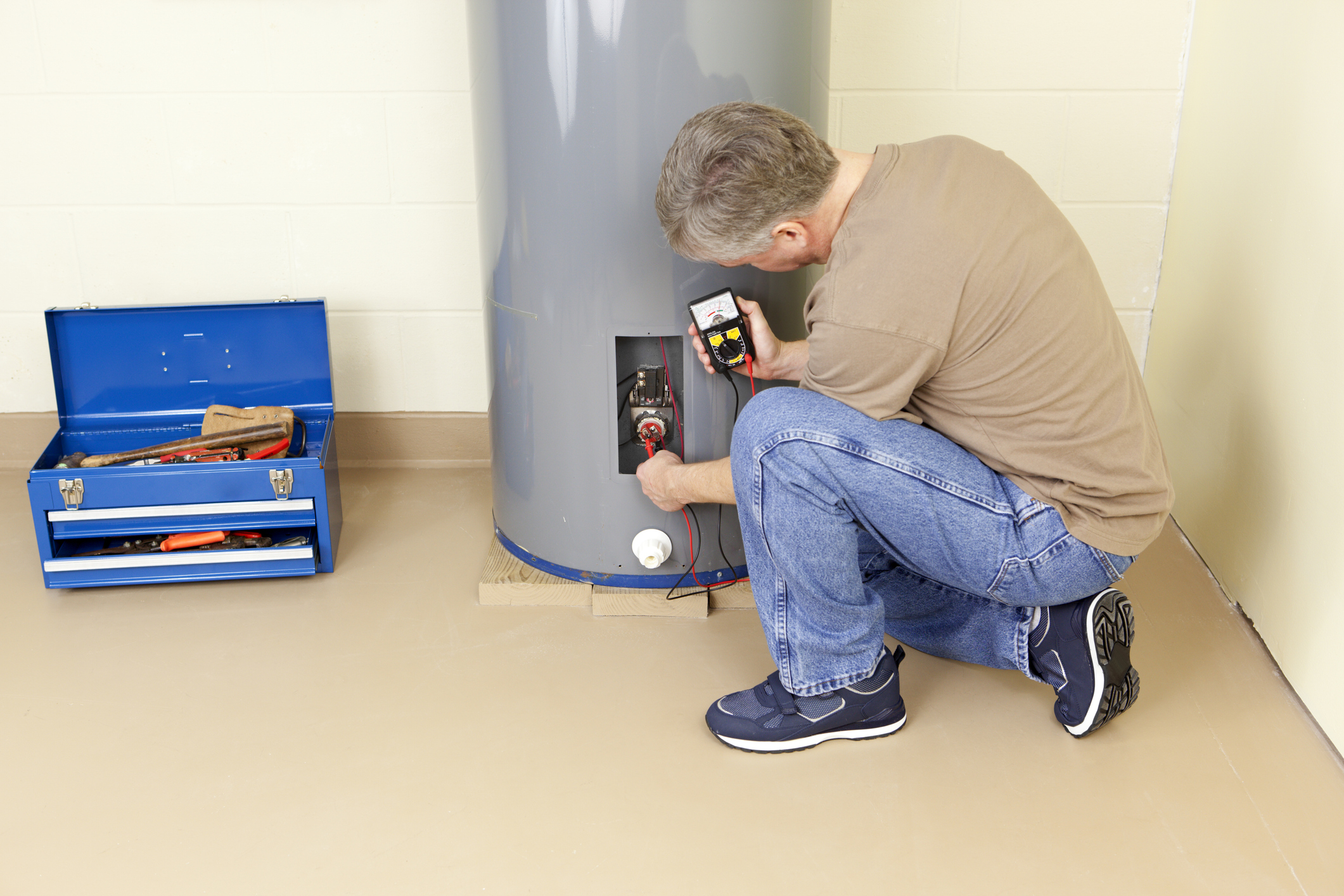 A worker repairing a water heater unit